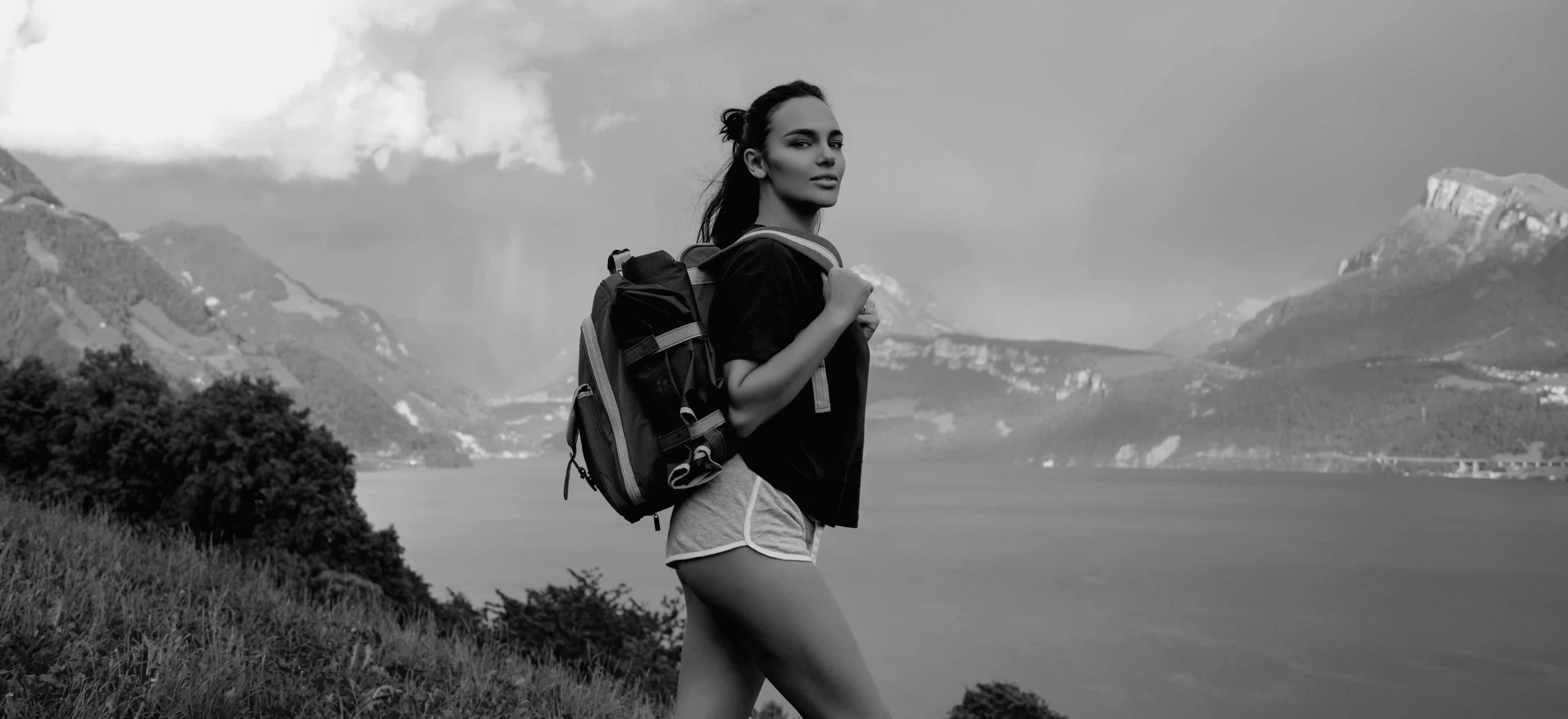 Woman sitting alone on blue chair facing stormy ocean on rocky beach, life transitions personal growth and navigating change for women